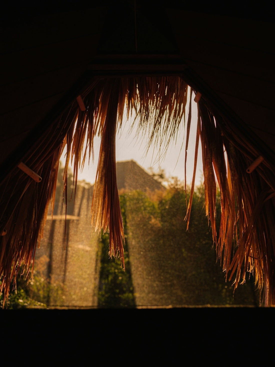 Sunrise from the perspective of inside a grass hut