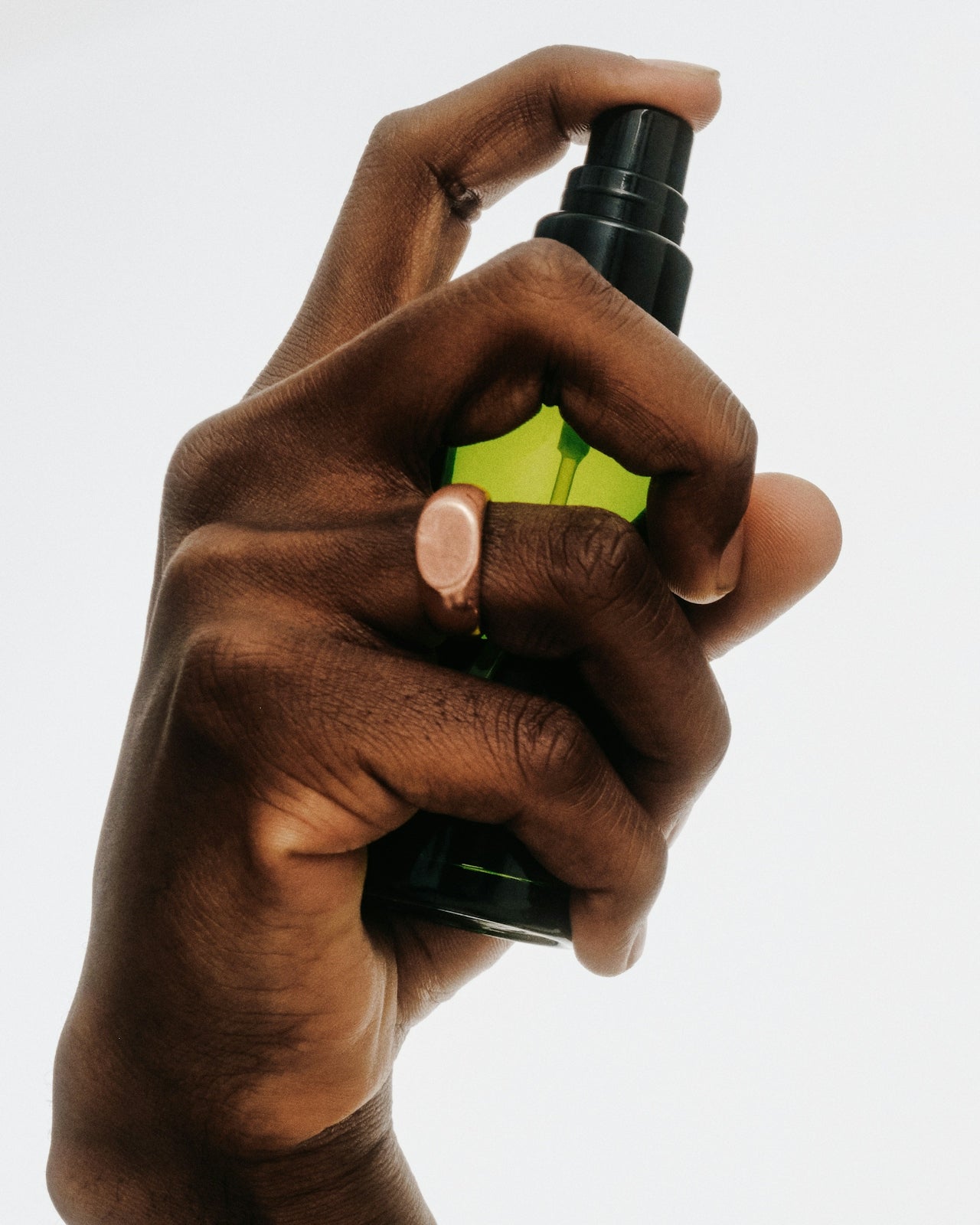 Hand holding a spray bottle with a clear background